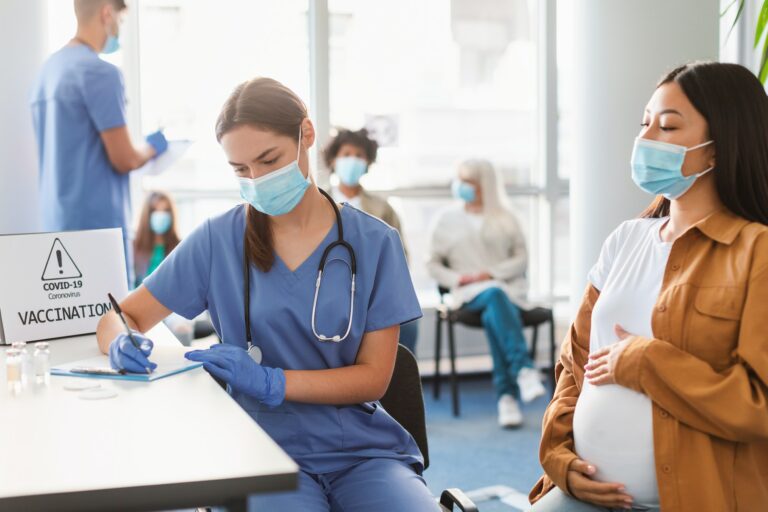 Pregnant Lady In Mask On Appointment At Doctor's Office