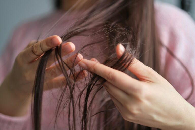 closeup female holding messy unbrushed dry hair in Hands. Hair damage concept.